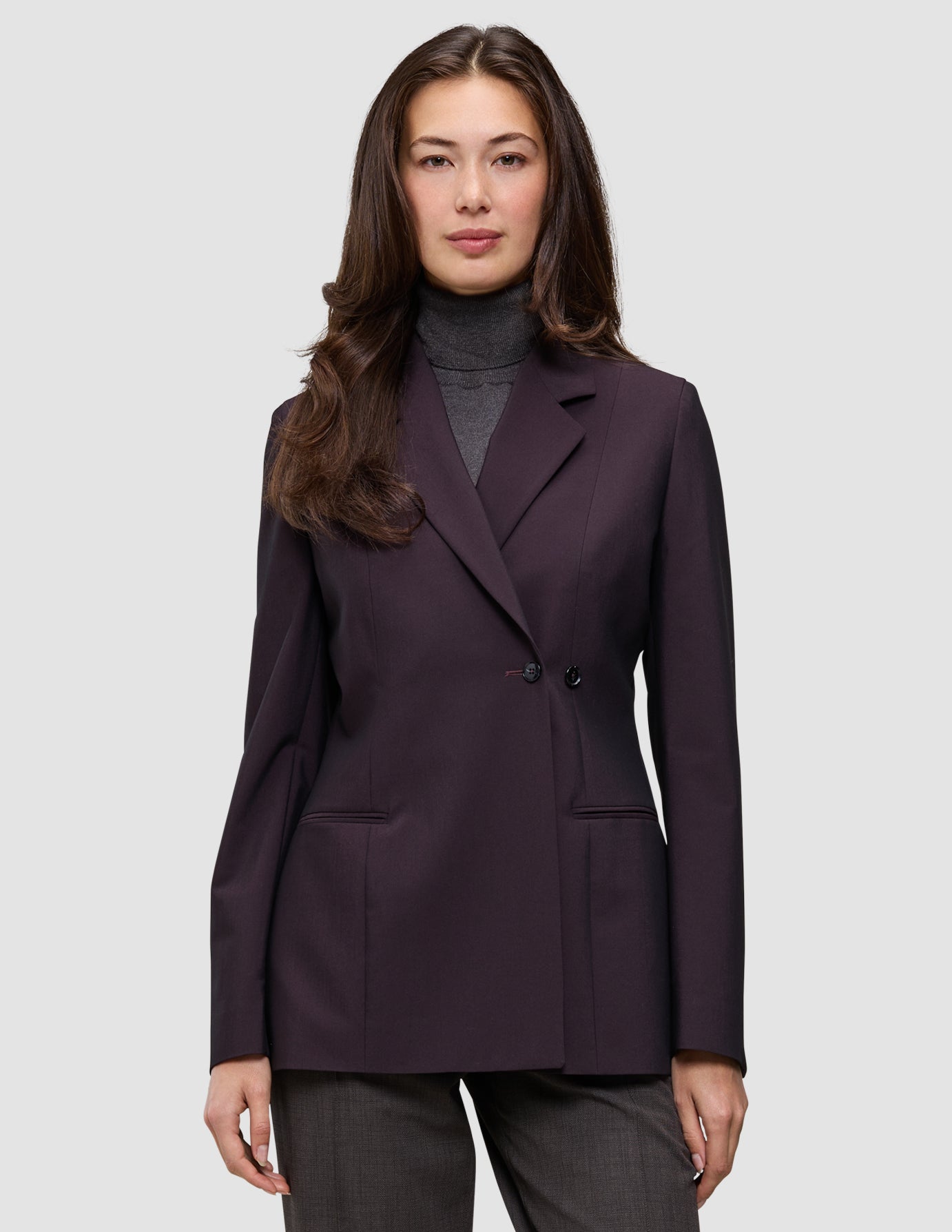 En person som har på seg en Women’s Avira Blazer Burgundy Berry over en grå turtleneck.